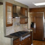 Kitchen with wall cabinetry stainless steel hood and stove and stone back-splash