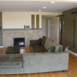 Open living space with wood floors and stone fireplace