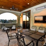 a luxurious balcony with an outdoor dining area and outdoor television