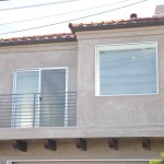 new stucco, windows and a sleek horizontal railing give this home a clean modern look