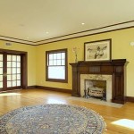 Remodeled living room area with hardwood floor, fireplace, crown and base molding and french door