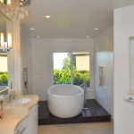 Modern bathroom with oval white soaking tub under large garden window