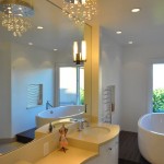 Modern bathroom with white cabinets white counter top wall mirror and modern light fixture