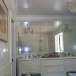 White bathroom cabinetry with wall mirror