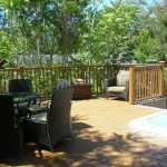 Wood deck with relaxation area with chairs and table surrounded by wood fence