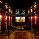 Home theater with red upholstery on the walls white and black wall paper and painted ceiling