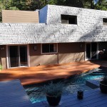 Renovated House exterior with stained concrete floor leading to pool and deck area